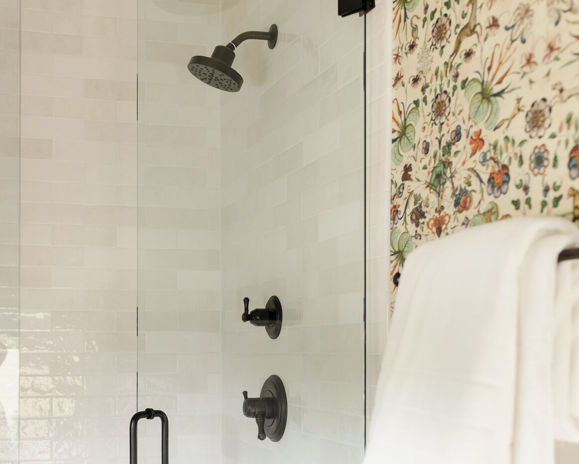 A bathroom with a shower, a towel rack, and a toilet.