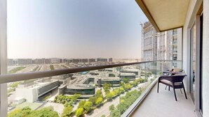 A balcony with a clear view of a cityscape, including high-rise buildings and a mix of commercial and residential structures.