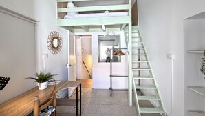 Una habitación con literas, un escritorio y una escalera.