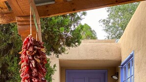 A building with a blue door labeled "Casa Alba," a hanging red chili pepper arrangement, and a large green pot. - Lovely 4 Bedroom Adobe Minutes to Plaza & Dog-Friendly (Santa Fe)