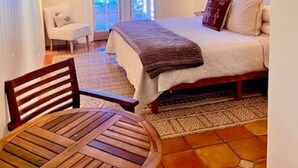 A bedroom with a bed, a chair, a table, and a wooden ceiling. - Lovely 4 Bedroom Adobe Minutes to Plaza & Dog-Friendly (Santa Fe)