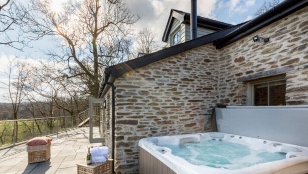 Een stenen gebouw met een jacuzzi en een terras.