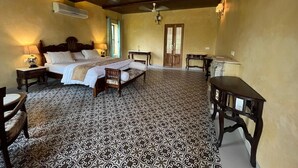 Une chambre spacieuse avec un grand lit, un bureau et une chaise.