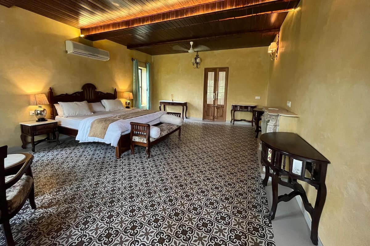 Une chambre spacieuse avec un grand lit, un bureau et une chaise.