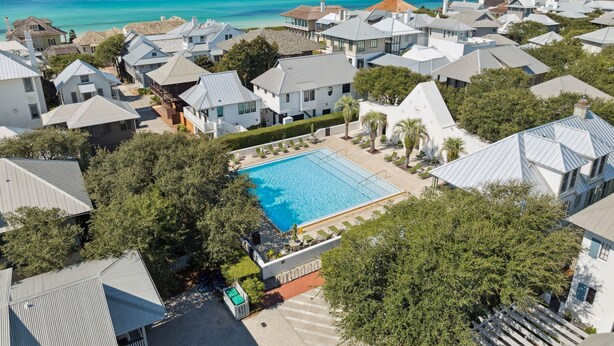A residential area with a swimming pool surrounded by houses with metal roofs.