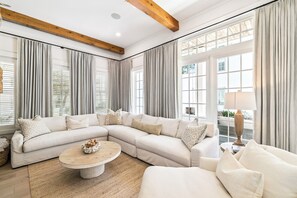 A modern living room with a sectional sofa, a round coffee table, and a lamp.
