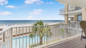 Un balcon avec vue sur une plage et une piscine.