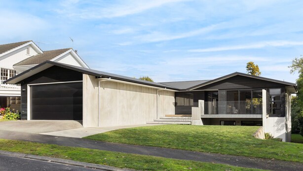 Une maison moderne à deux étages, dotée d’un garage, d’un porche abrité et d’une pelouse bien entretenue.