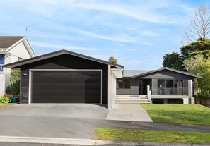 A modern two-story house with a garage, a covered porch, and a well-maintained lawn. - All Black # 10 (Hamilton)