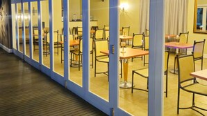 A corridor with a series of rooms, each with a table and chairs, and a view of the ship's deck. - Presidential Boutique Hotel (Durban North)