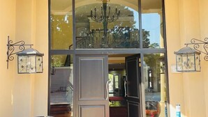 A grand entrance with a large glass door, a red carpet, and two large vases on either side. - Presidential Boutique Hotel (Durban North)