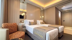 Ett hotellrum med två sängar, en soffa, ett skrivbord och en spegel.