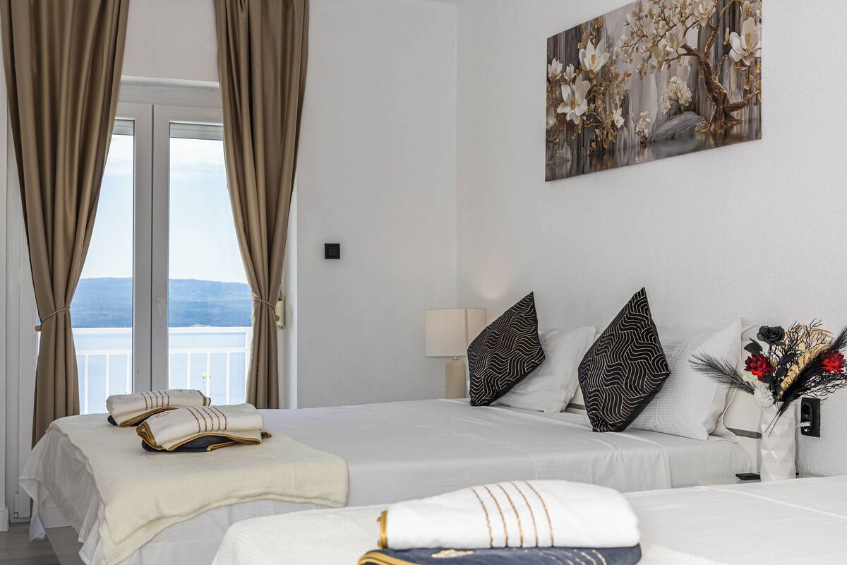 Habitación de hotel con dos camas, un balcón y un cuadro en la pared.