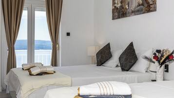 Habitació d'hotel amb dos llits, un balcó i un quadre a la paret.