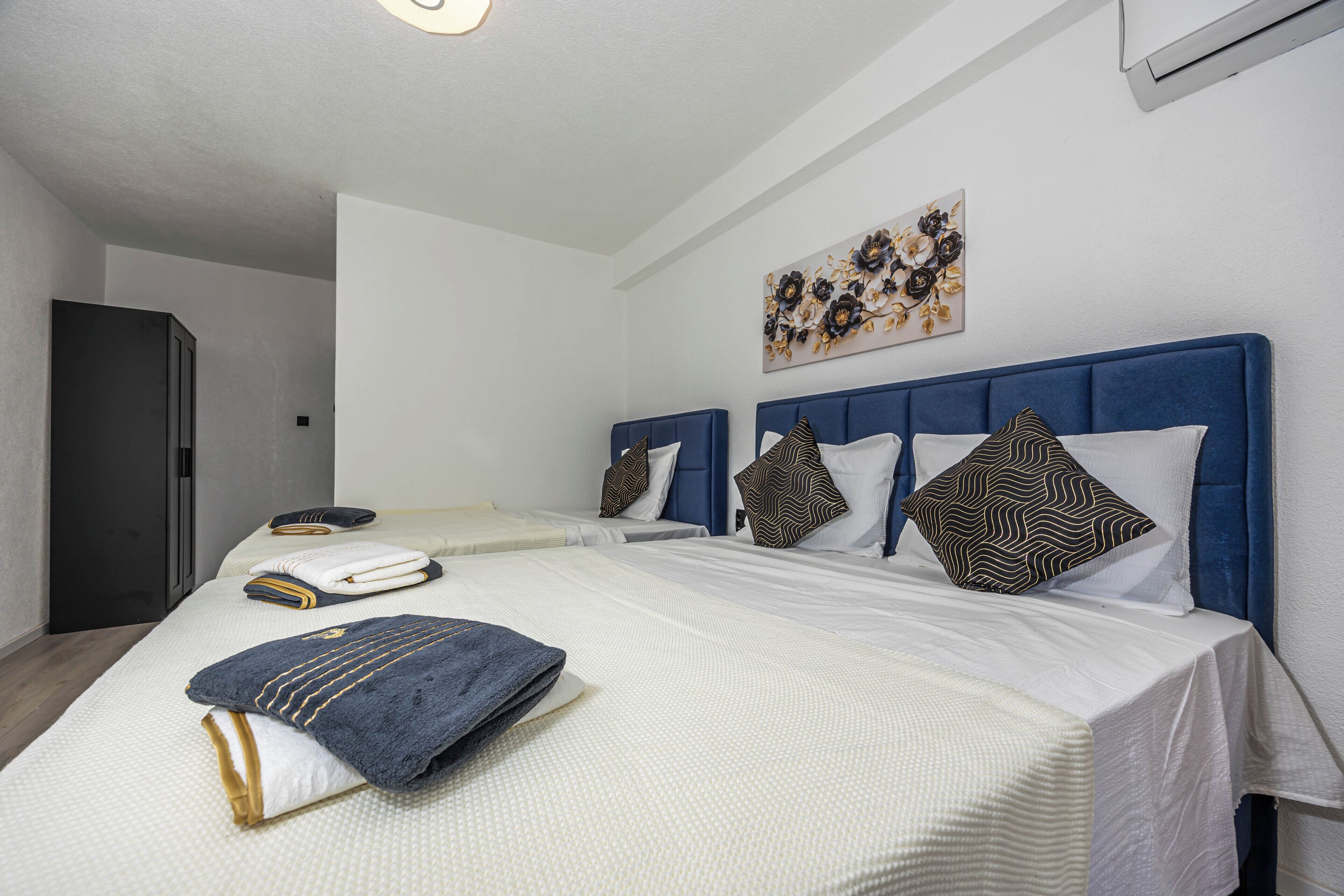 Habitación de hotel con una cama grande, un escritorio y un aire acondicionado de pared.