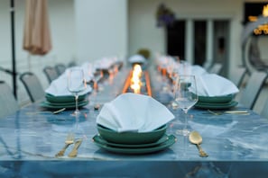 A dining table set with green plates, white napkins, and gold cutlery. - Royal Elysee (Dramalj)