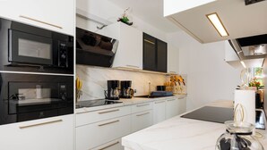 Una cocina moderna con microondas, estufa y cafetera.