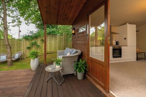 A wooden deck with wicker furniture, potted plants, and a view of a backyard. - The Hideaway Lower Shockerwick Lodge  (Bath)