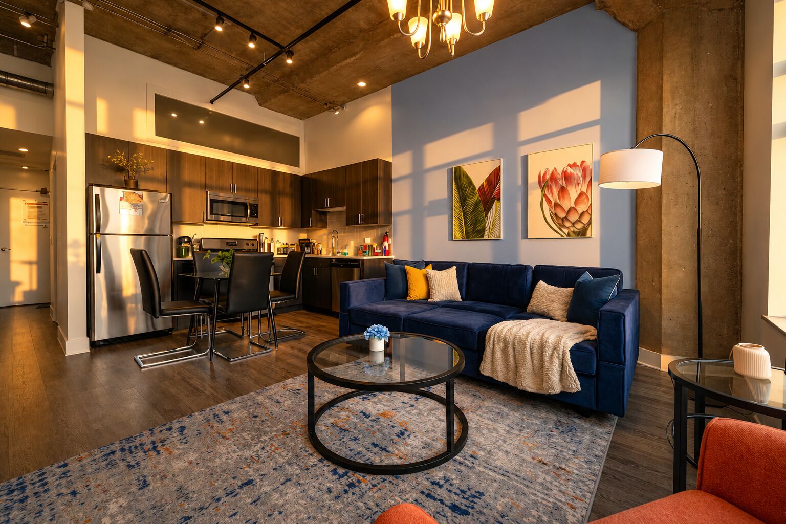 A modern living room with a sofa, coffee table, and a dining area with chairs.