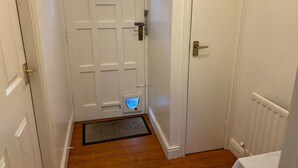 A hallway with a white door featuring a blue light and a small window. - Budget Carlisle Home for 4 | Parking & Garden (Carlisle)