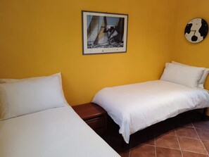 A room with two beds, a small table, a framed picture on the wall, and a clock. - Ranocchio House, Perfect Retreat for a Relaxing Stay Just a few Steps From Rome (Sacrofano)