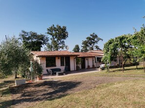 A two-story house with a tiled roof, a satellite dish, and a patio with outdoor furniture. - Ranocchio House, Perfect Retreat for a Relaxing Stay Just a few Steps From Rome (Sacrofano)