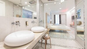 Un baño moderno con dos lavamanos grandes, un espejo y una ducha.