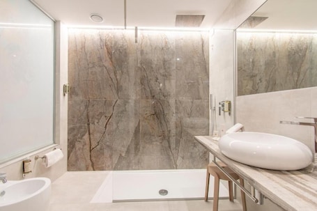 Un bagno moderno con parete in marmo, lavandino bianco e zona doccia.. Max Motel - Art Gallery Room