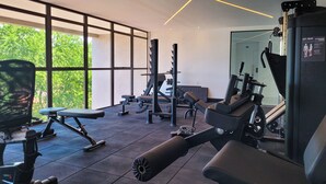 Un gimnasio moderno con equipo de ejercicio, ventanas amplias y un diseño limpio y minimalista.