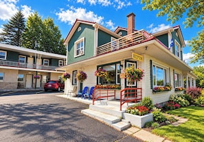 A two-story building with a reception area, outdoor seating, and a parking lot. - motel St Hilaire (Mont-Saint-Hilaire)
