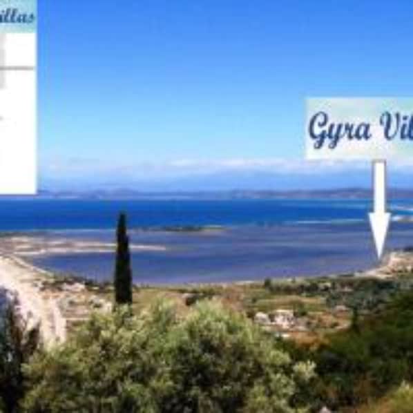 Kystlandskab med et skilt, der viser vejen til Gyria Village.