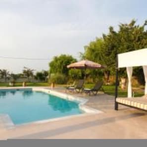 A swimming pool with lounge chairs and umbrellas. - Villa Fivos With Private Pool by Lefkadastay (Lefkada)