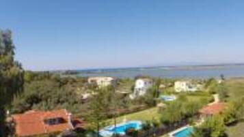 Un barrio residencial con casas, piscina y vista despejada al mar.
