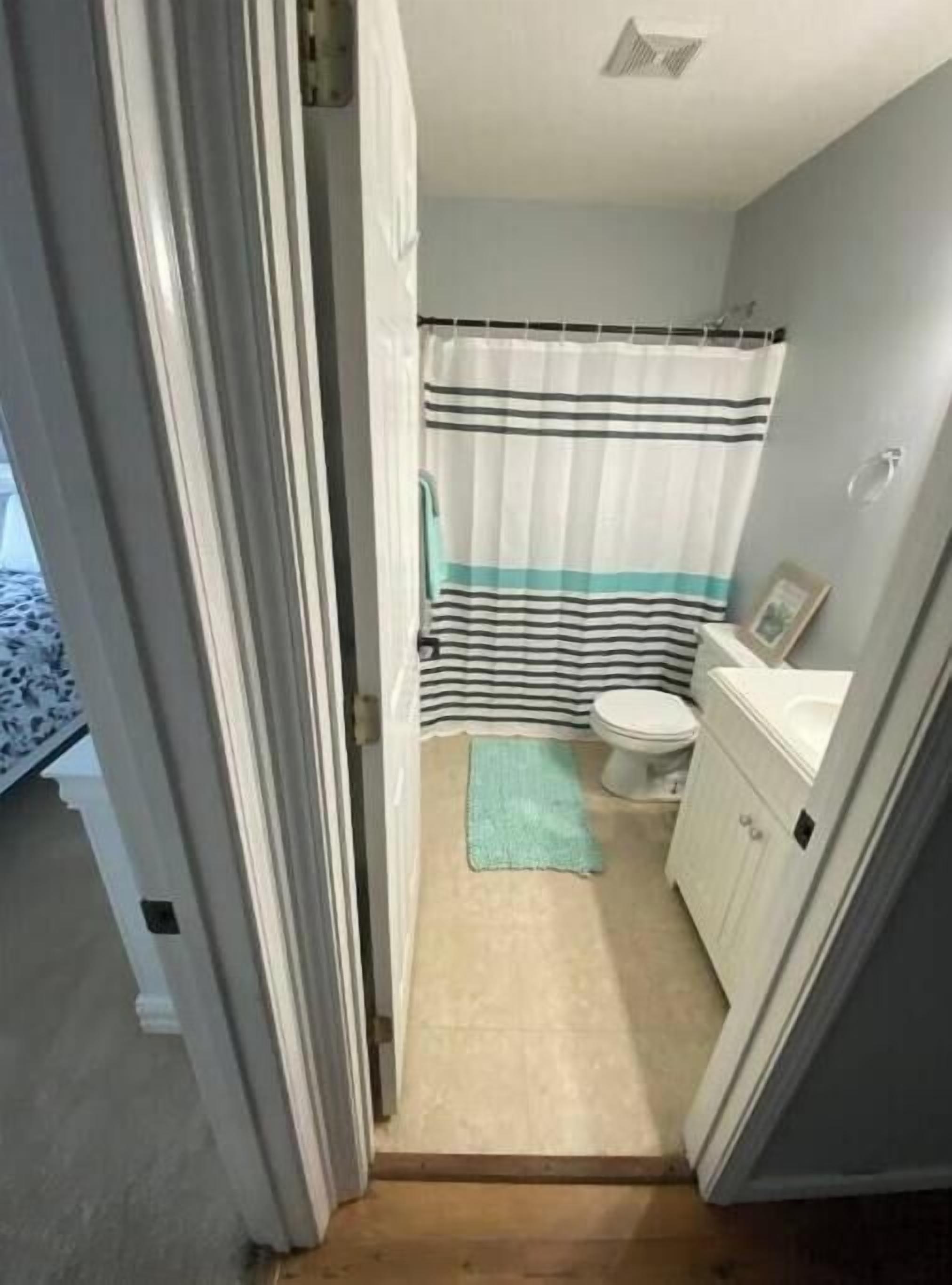 A small bathroom with a toilet, a sink, and a shower curtain.
