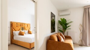 Une chambre d’hôtel moderne, équipée d’un lit, d’un canapé et d’une grande plante.