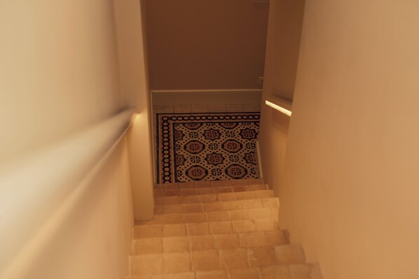 A staircase with a patterned tile wall at the bottom.