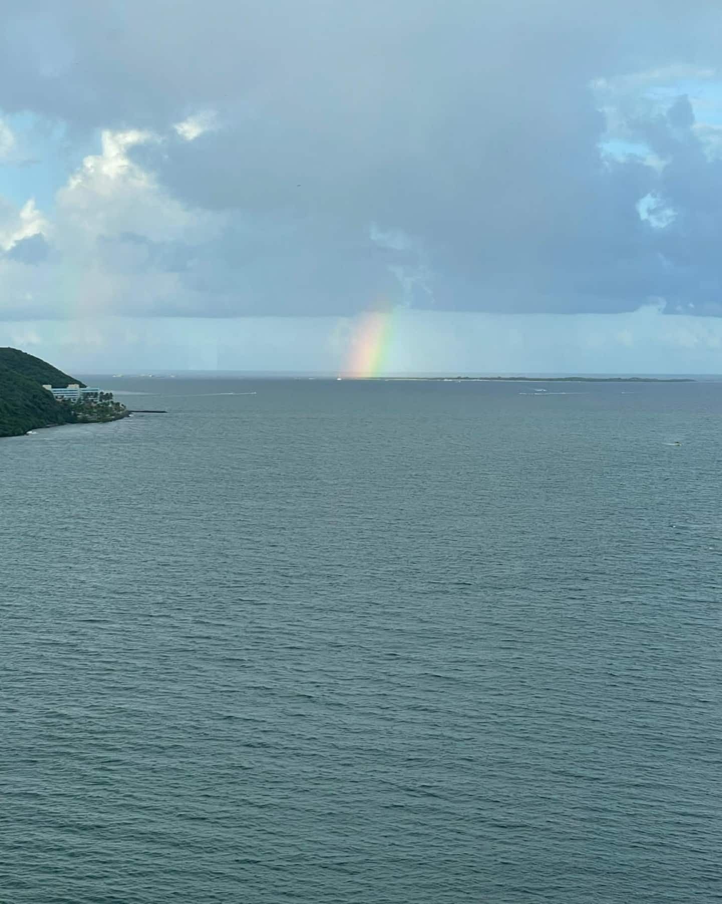 A view of a body of water with a rainbow in the distance.