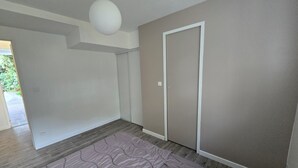 Una habitación con una cama grande, una puerta y una lámpara colgante.