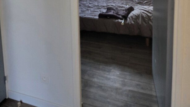 Un dormitorio con cama, ventana y puerta que da a otra habitación.