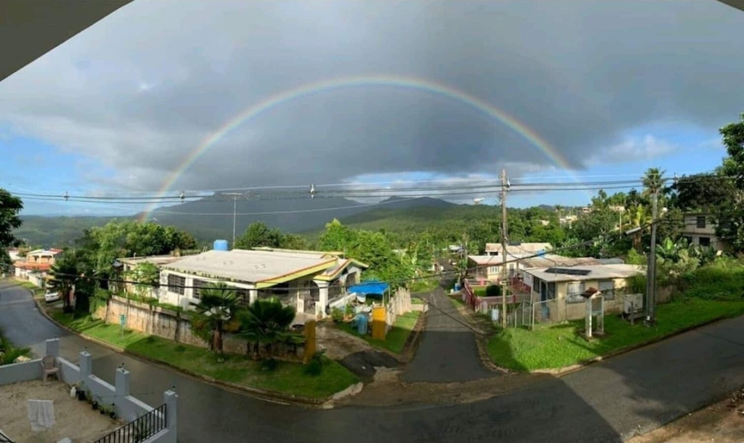 A residential area with houses, a road, and a mountain in the background.