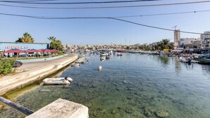 Un port de plaisance avec des bateaux amarrés, une rive dégagée et des bâtiments en arrière-plan.