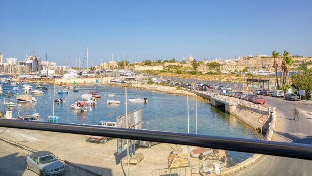 Un port de plaisance avec des bateaux, un pont et une vue sur la ville en arrière-plan.