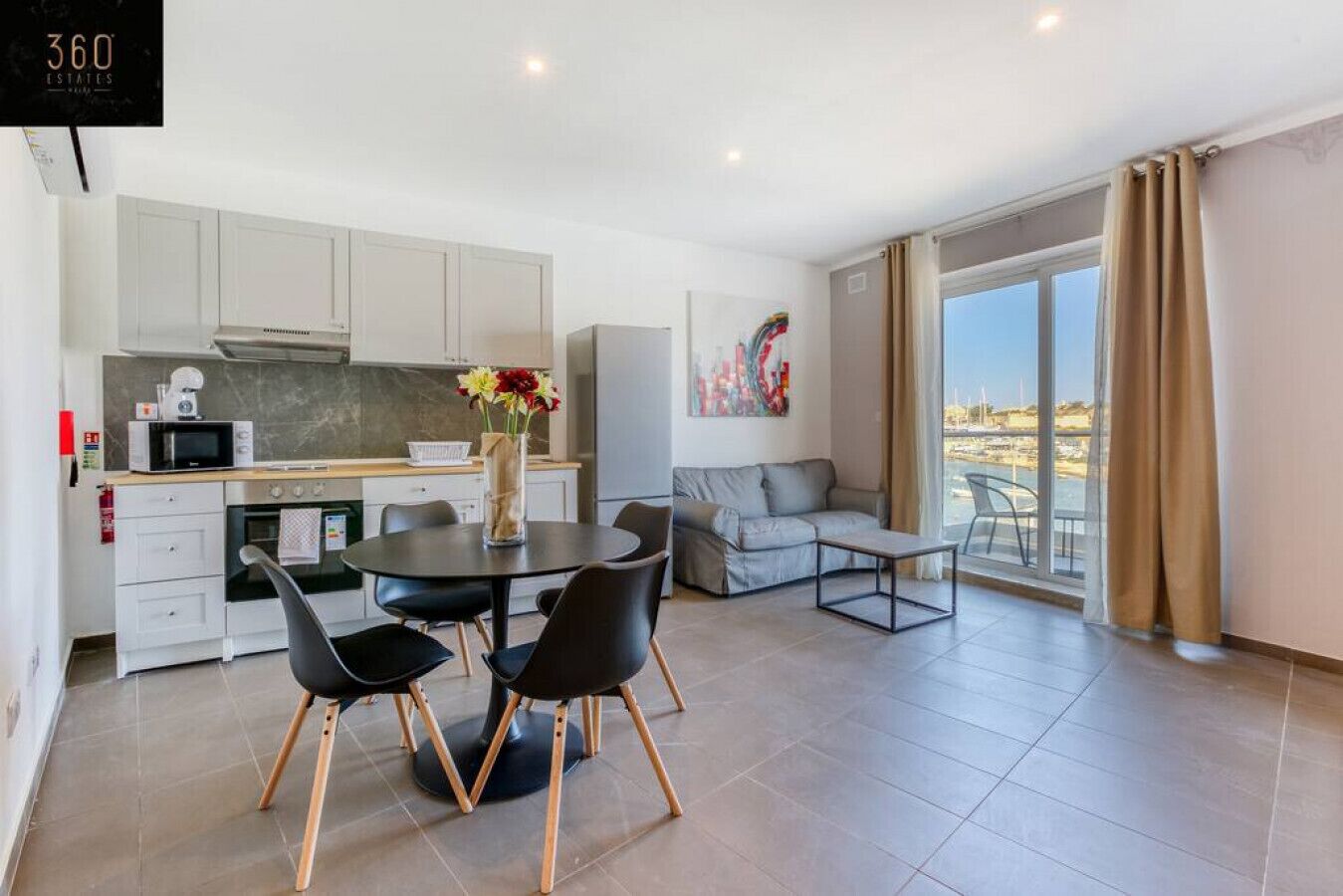 Un apartamento moderno con cocina, comedor y balcón con vistas.