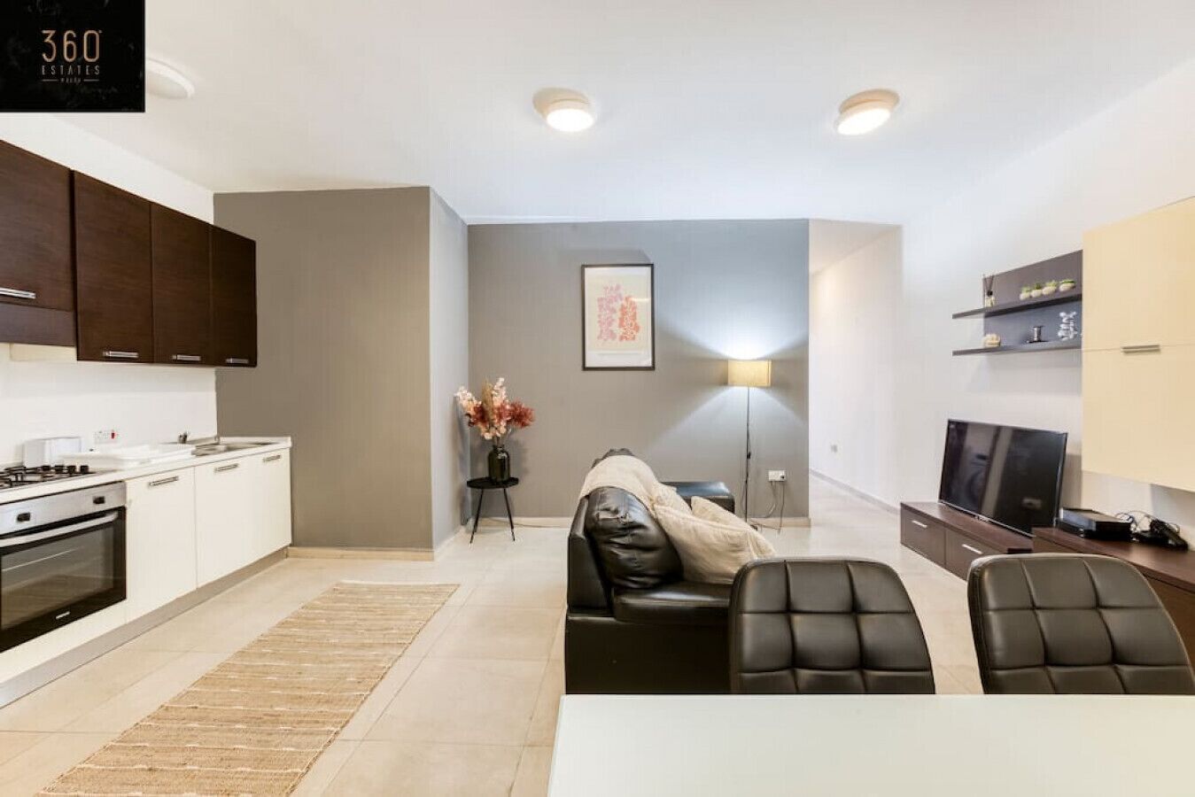 Un appartamento moderno con cucina, zona pranzo e soggiorno.