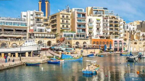 A coastal cityscape with a marina, buildings with balconies, and a variety of boats. - Cozy 1BR home in the centre of St Julians w/WIFI (San Ġiljan)