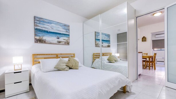 A bedroom with two beds, a nightstand, a desk, and a chair. - Peaceful 1BR maisonette with Sofa Bed with WIFI ! (San Pawl il-Baħar)