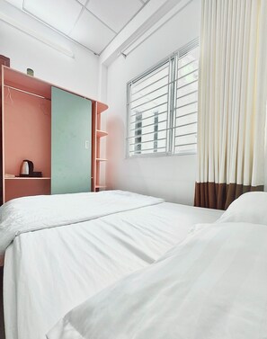 A hotel room with two beds, a wardrobe, a window with blinds, and a curtain. - The Hidden Hogwarts - Nearly Bui Vien (Ho Chi Minh City)