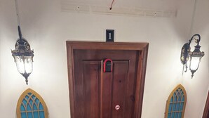 Una puerta de madera con un letrero de número, un cartel de prohibido fumar y una cerradura.