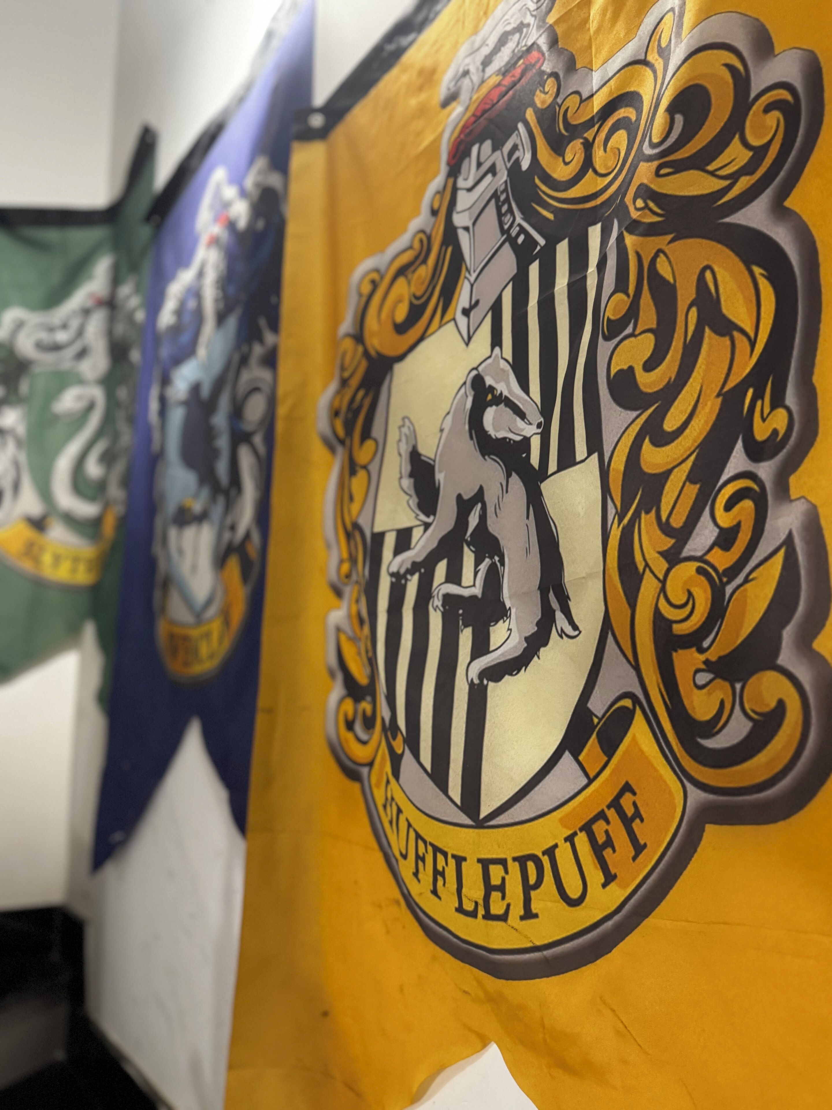 Una pared con un gran emblema que muestra un grifo y la palabra "Hufflepuff".
