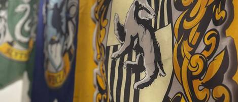 Una pared con un gran emblema que muestra un grifo y la palabra "Hufflepuff".